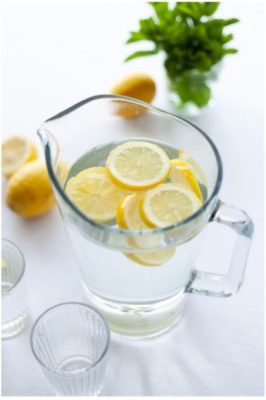pitcher of water with lemon slices in it